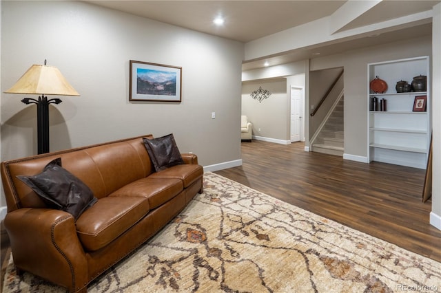 living room featuring recessed lighting, wood finished floors, baseboards, and stairs