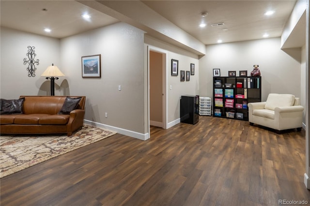 living area with dark wood-style flooring, recessed lighting, visible vents, and baseboards