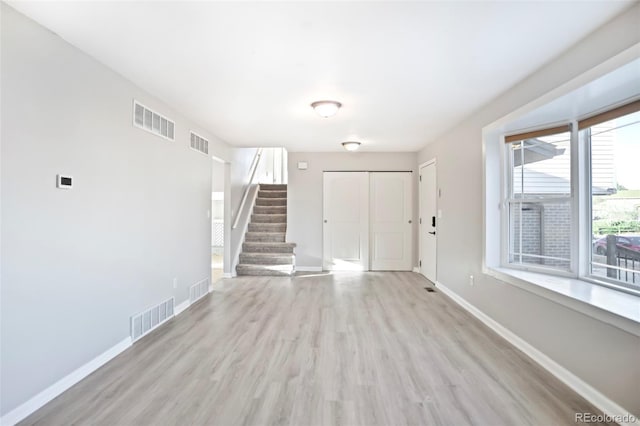 foyer entrance featuring stairway, baseboards, and visible vents