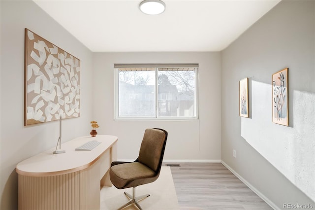 office with light wood-type flooring, baseboards, and visible vents