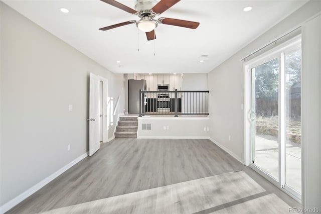 unfurnished living room featuring visible vents, baseboards, stairway, recessed lighting, and light wood-style flooring