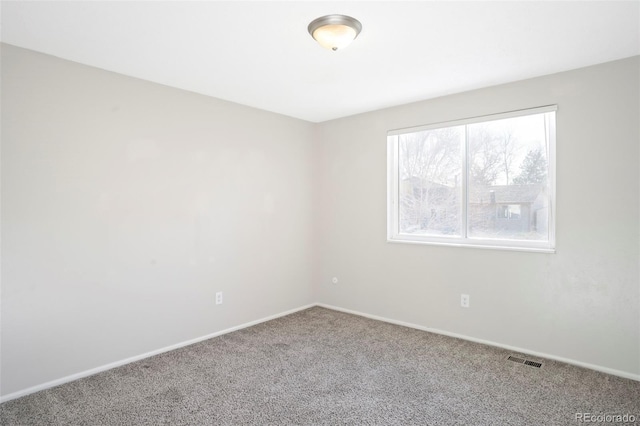 carpeted empty room featuring visible vents and baseboards