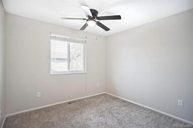 spare room featuring visible vents, carpet floors, baseboards, and ceiling fan