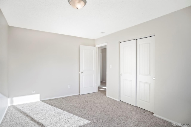 unfurnished bedroom with baseboards, a closet, and carpet floors