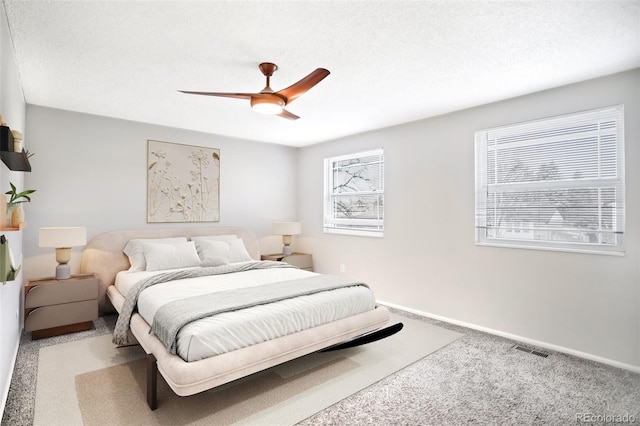 bedroom with visible vents, a textured ceiling, and baseboards