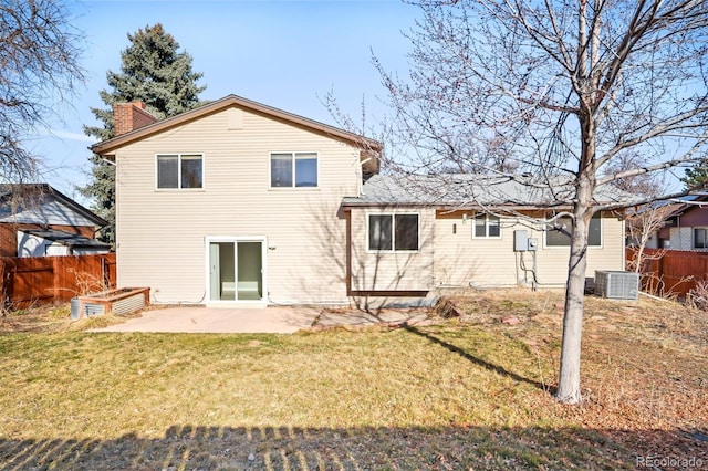 back of house with fence, central air condition unit, a chimney, a yard, and a patio