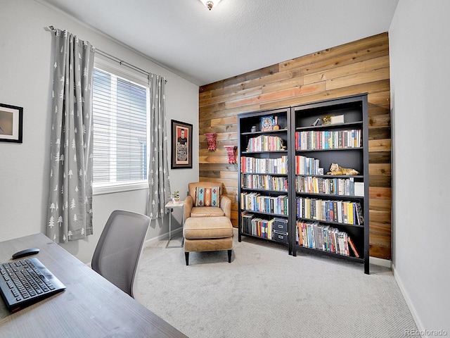 carpeted office featuring wood walls and baseboards