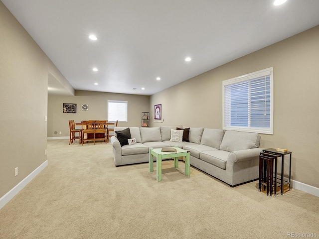 living room with recessed lighting, light colored carpet, and baseboards