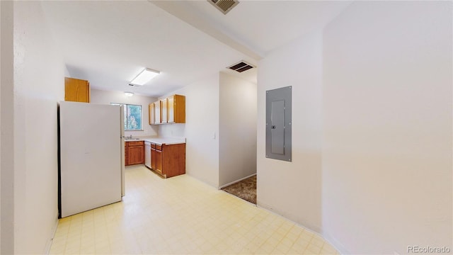 kitchen featuring stainless steel dishwasher, white refrigerator, and electric panel