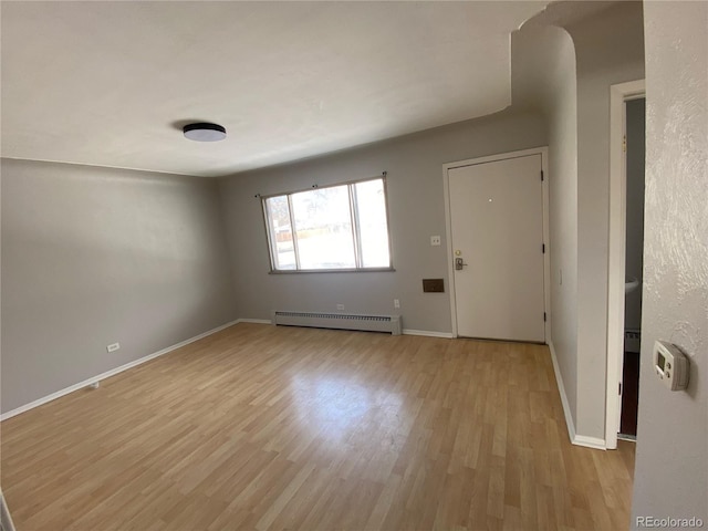 interior space with light wood-type flooring and a baseboard radiator