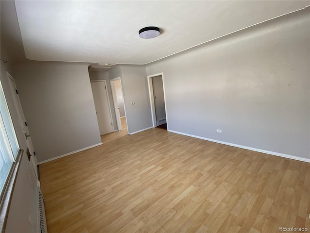 unfurnished bedroom with baseboard heating and light hardwood / wood-style flooring