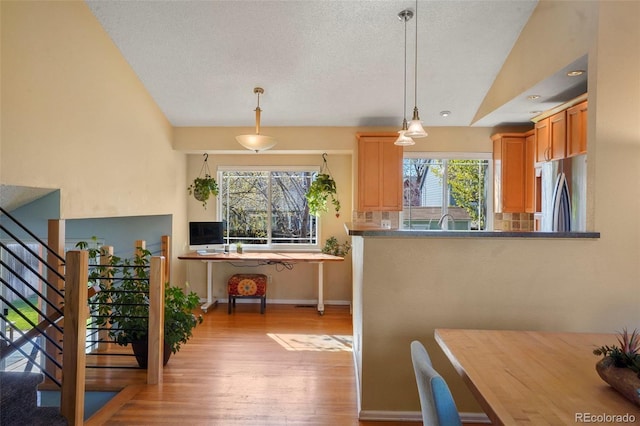 11446 W 105th Dr, Broomfield, CO 80021 - kitchen with light wood-type flooring, a textured ceiling, stainless steel refrigerator, and hanging light fixtures