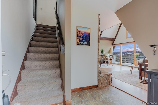 8691 S Warhawk Rd, Conifer, CO 80433 - staircase with baseboards, a high ceiling, and stone finish floors