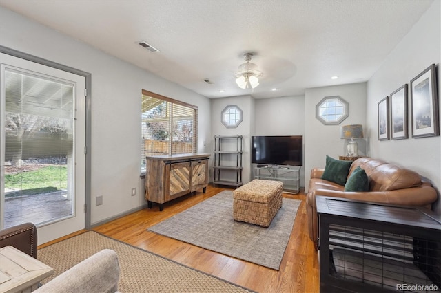 living room featuring a ceiling fan, visible vents, recessed lighting, light wood finished floors, and baseboards