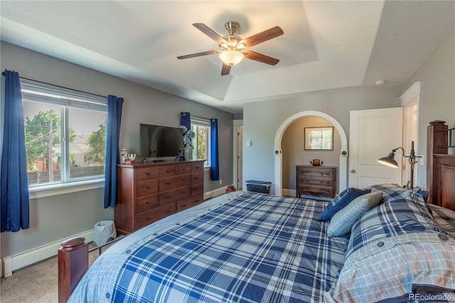 bedroom featuring baseboards, arched walkways, carpet, a tray ceiling, and baseboard heating