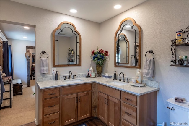 bathroom featuring double vanity, a sink, and recessed lighting