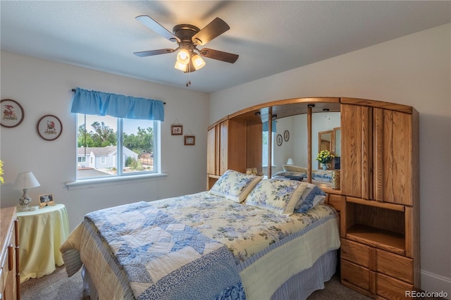 carpeted bedroom with arched walkways and a ceiling fan