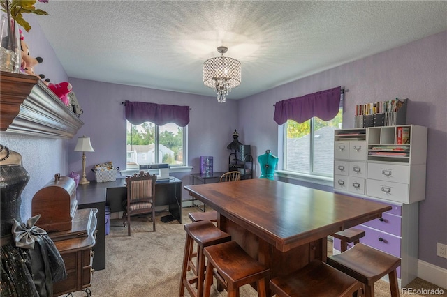 dining area featuring a chandelier, a textured ceiling, and light colored carpet