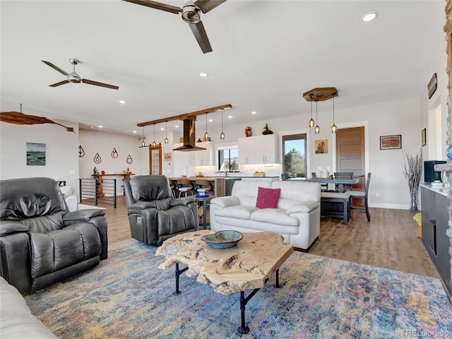 living area featuring recessed lighting, baseboards, light wood-style floors, and ceiling fan