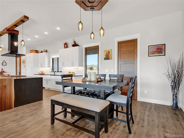 dining area featuring recessed lighting, light wood-style flooring, and baseboards