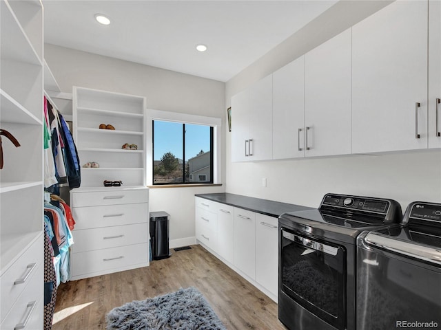 clothes washing area with recessed lighting, light wood-style floors, cabinet space, and separate washer and dryer