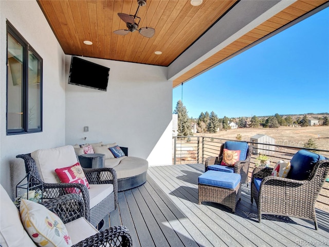 wooden terrace featuring an outdoor hangout area and ceiling fan