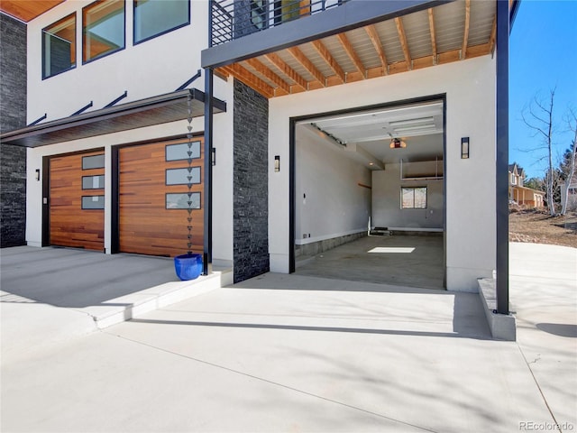 exterior space featuring concrete driveway, a garage, and stucco siding