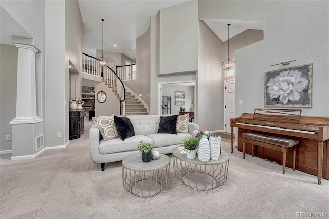 living room featuring visible vents, baseboards, carpet, stairway, and a towering ceiling