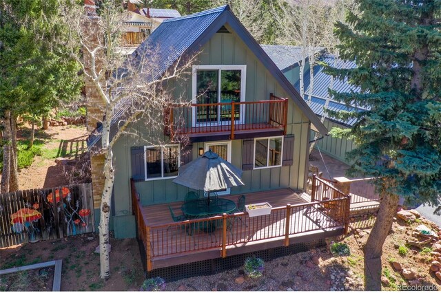 rear view of house with a balcony, a wooden deck, and board and batten siding