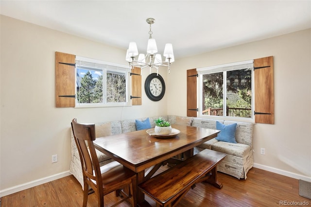 dining room featuring breakfast area, a notable chandelier, baseboards, and wood finished floors