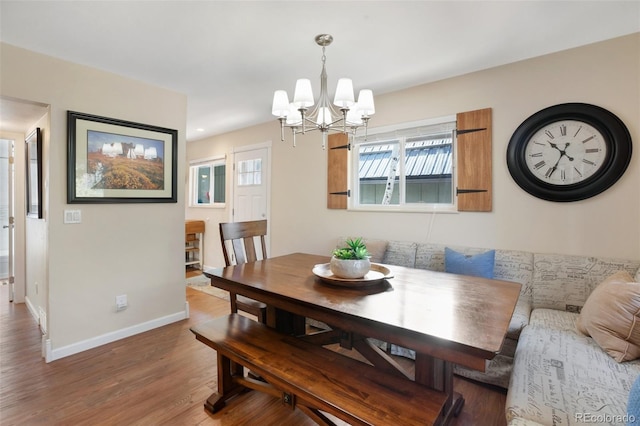 dining area featuring a chandelier, wood finished floors, and baseboards