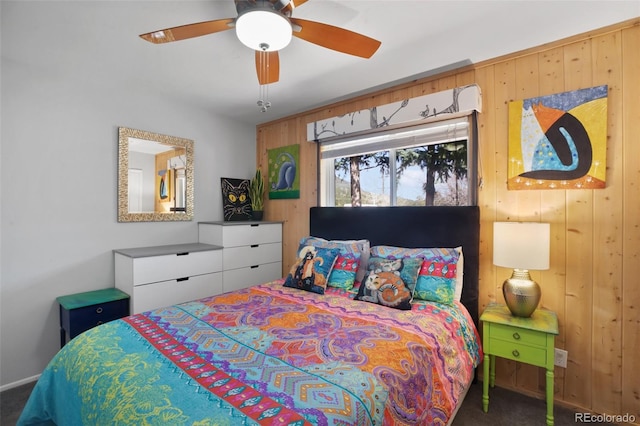 bedroom featuring wooden walls, a ceiling fan, and carpet floors