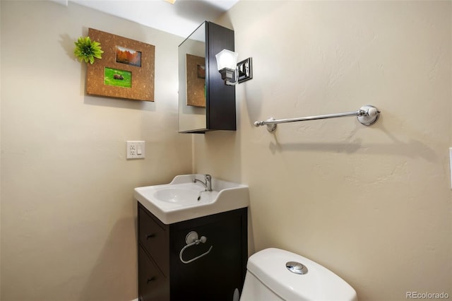 half bathroom featuring toilet and vanity