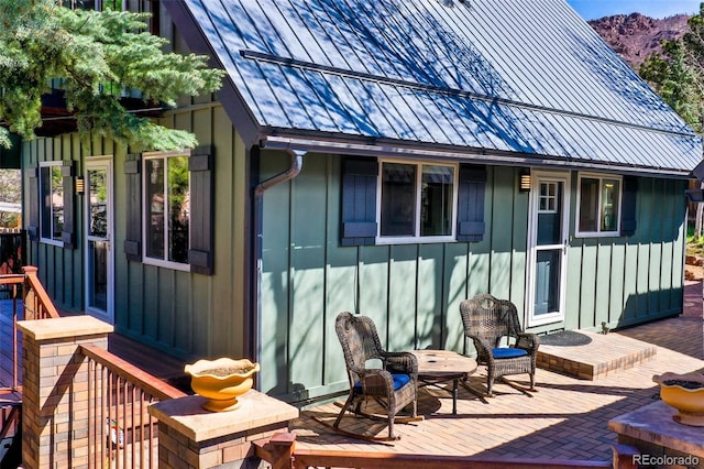 back of house featuring a mountain view, board and batten siding, a patio, and metal roof