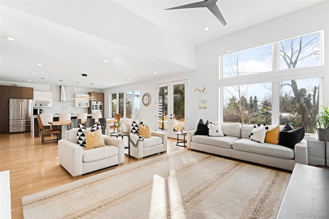 living room with french doors, ceiling fan, and light hardwood / wood-style flooring