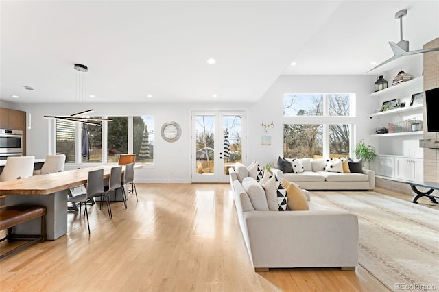 living room featuring a fireplace, light hardwood / wood-style flooring, and french doors