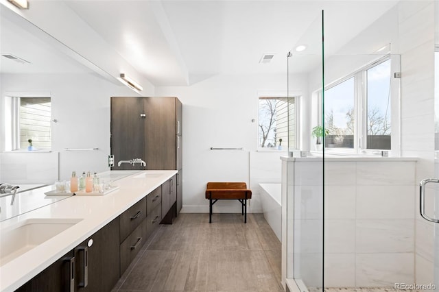 bathroom featuring vanity and shower with separate bathtub