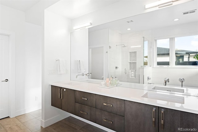 bathroom featuring vanity, tile patterned flooring, and walk in shower