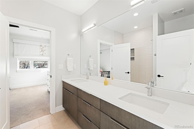 bathroom featuring tile patterned flooring, vanity, and a shower