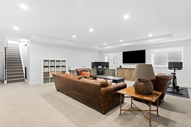 carpeted living room with a raised ceiling