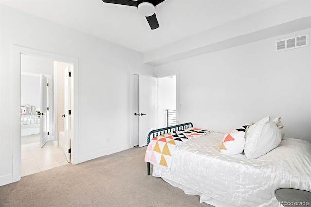 bedroom with ceiling fan, connected bathroom, and light colored carpet