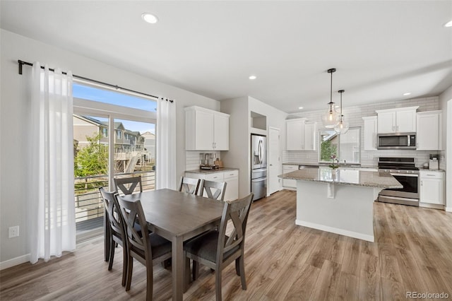 dining space with recessed lighting, baseboards, and light wood-type flooring