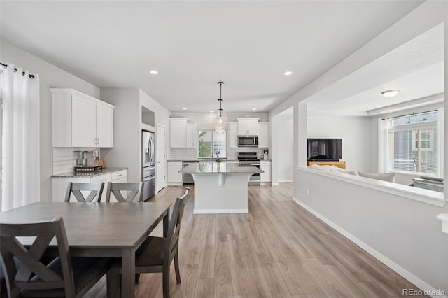 dining area with recessed lighting, baseboards, a healthy amount of sunlight, and light wood finished floors