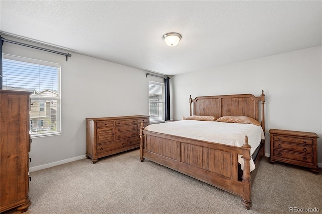 bedroom with baseboards and light colored carpet