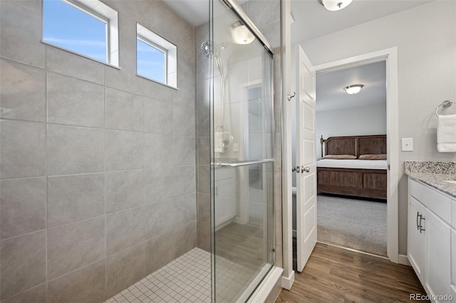 full bath with vanity, ensuite bath, a stall shower, and wood finished floors