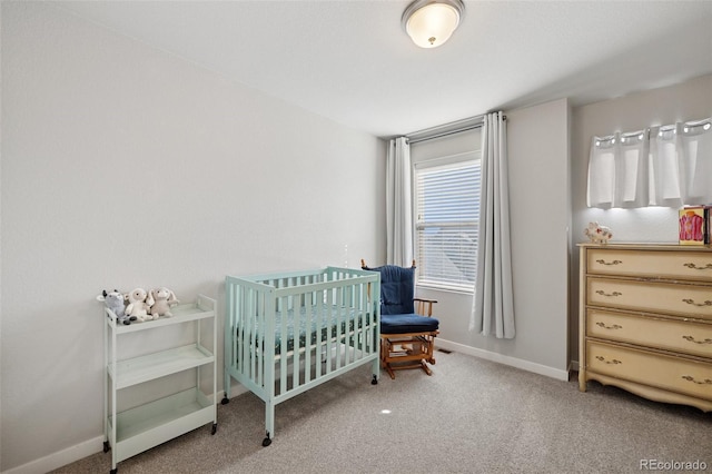 bedroom with carpet floors, baseboards, and a nursery area