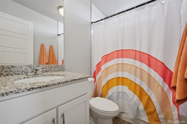 bathroom with vanity, curtained shower, toilet, and wood finished floors