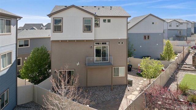 back of property featuring a residential view, a fenced backyard, and a balcony