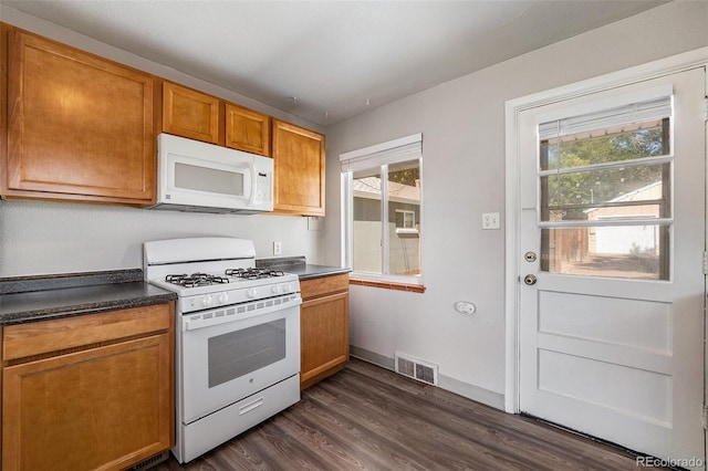 kitchen with white appliances, a wealth of natural light, and dark wood-type flooring