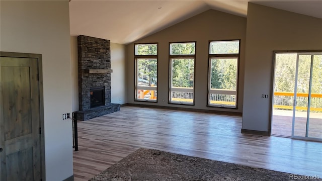 unfurnished living room featuring lofted ceiling, hardwood / wood-style flooring, and a fireplace